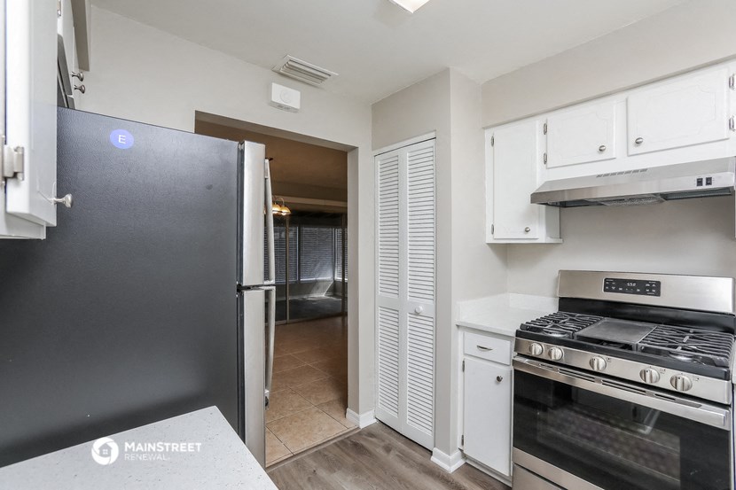 a kitchen with stainless steel appliances and white cabinets