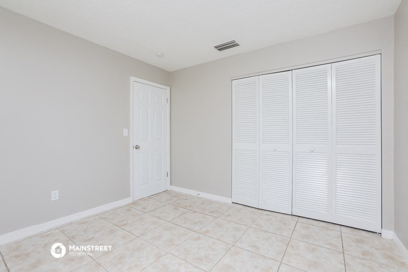 the spacious living room has tile flooring and large closets