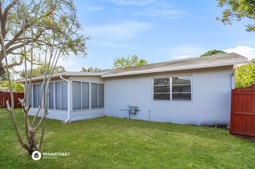 a white house with a yard and a tree