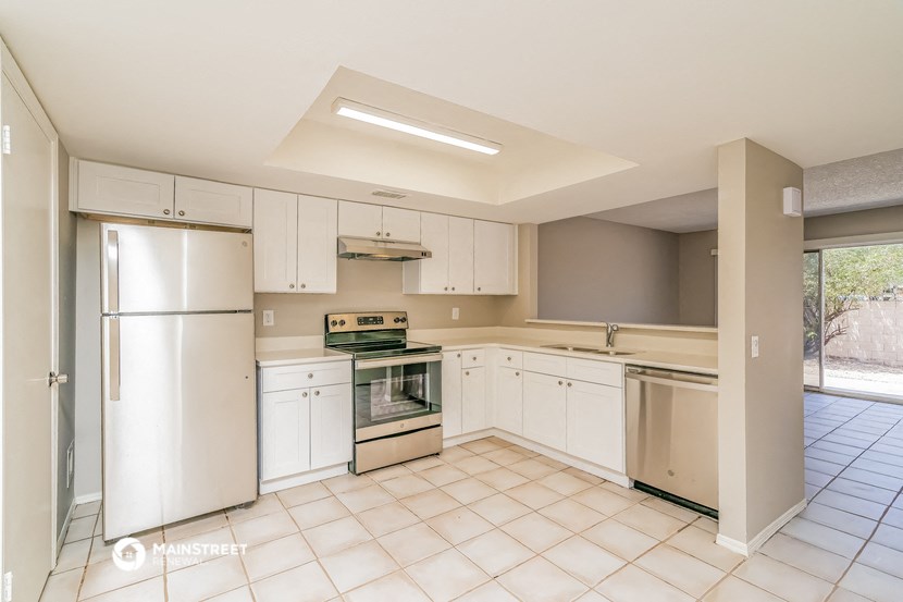 a kitchen with white cabinets and a refrigerator and a sink