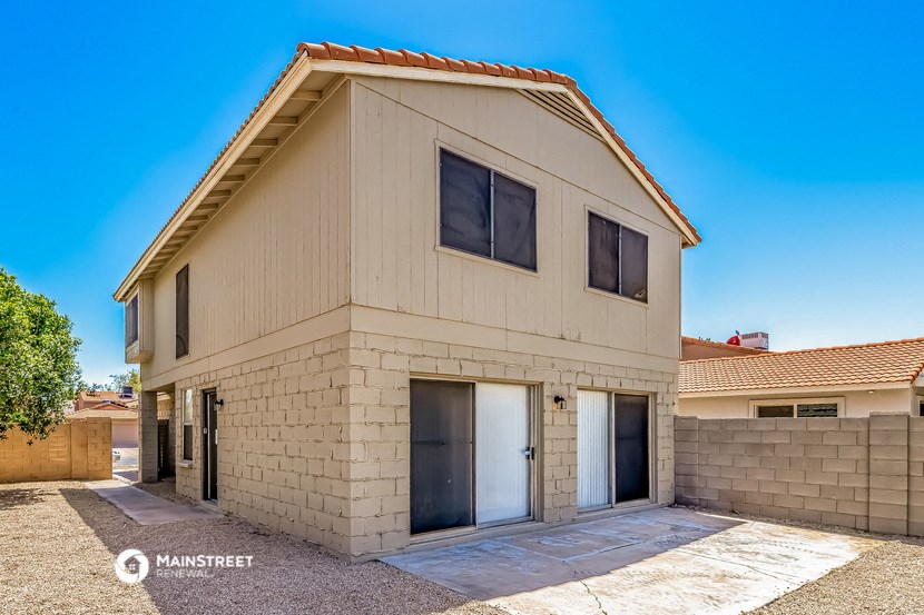 a white brick house with two doors and a driveway
