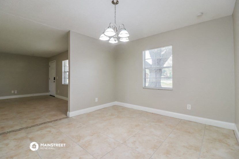 the living room and dining room of an empty house