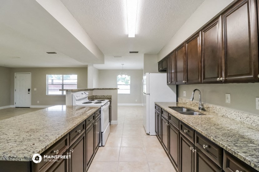 a large kitchen with granite counter tops and wooden cabinets