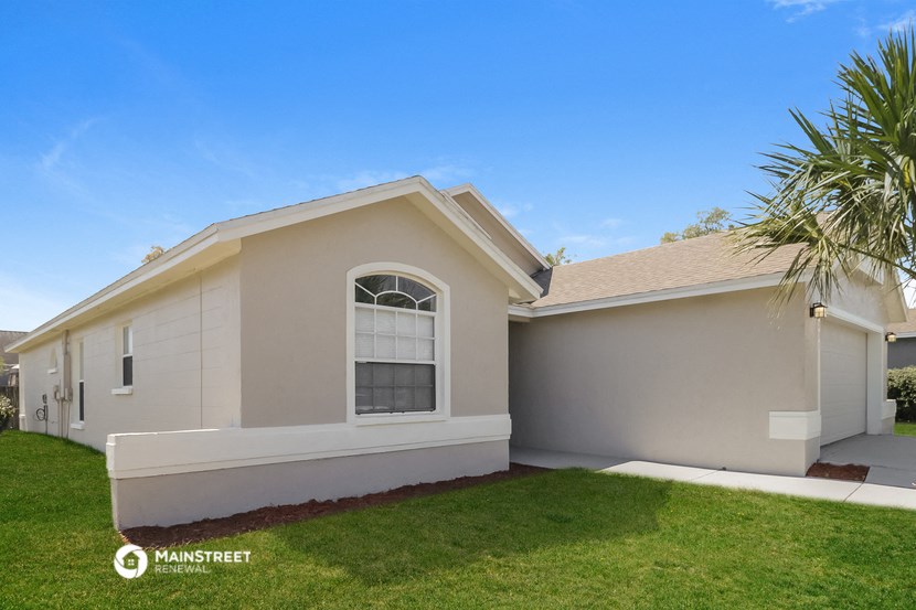 a beige house with a palm tree in the yard