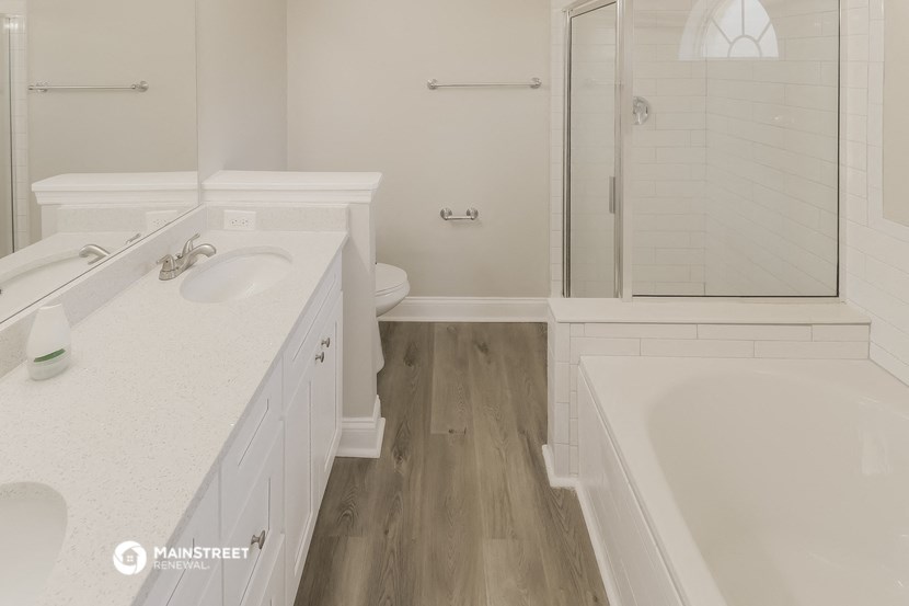 a white bathroom with a tub and a sink and a shower