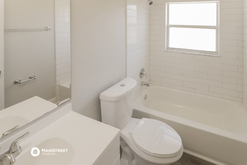 a white bathroom with a tub and a toilet and a sink