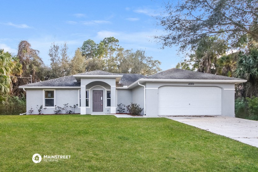 a white house with a lawn and a garage door