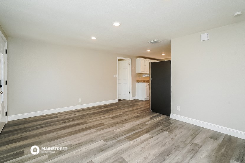 the living room and kitchen of a new home with wood flooring
