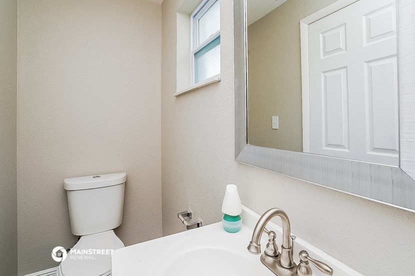 a bathroom with a mirror and a toilet and a sink