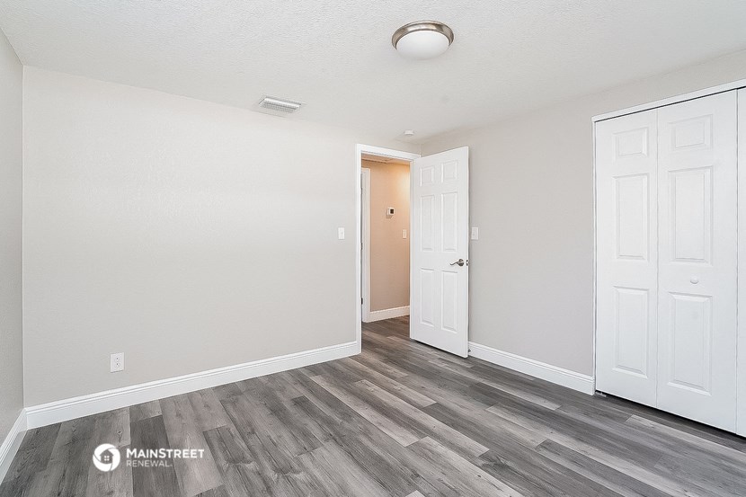 the living room of our studio apartment atrium with white walls and wood flooring
