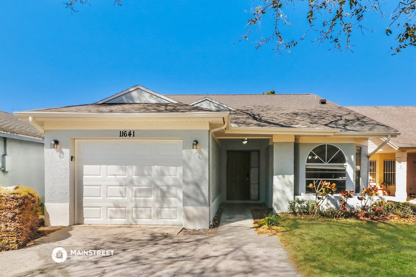 a white house with a white garage door and a lawn