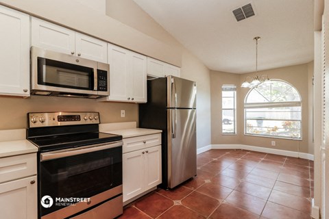 a kitchen with stainless steel appliances and white cabinets
