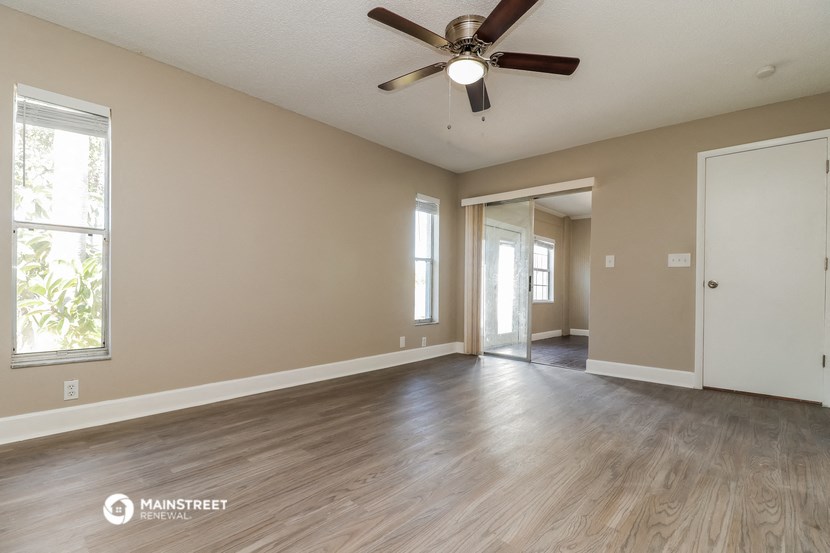 the spacious living room and dining room of an empty house