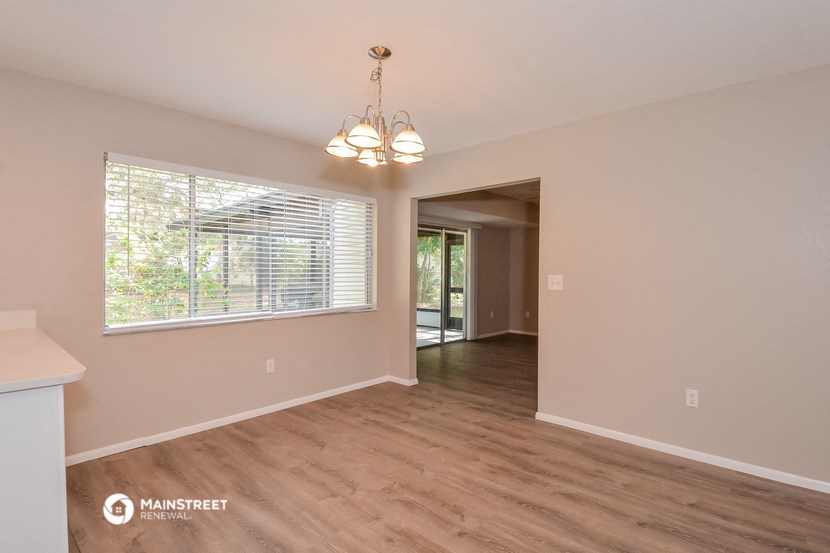 the living room and dining room of an empty house with a large window