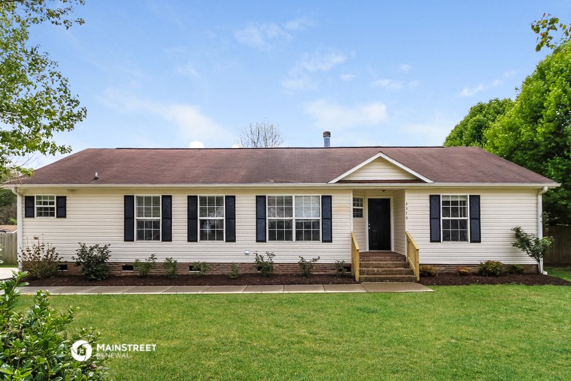 a white house with black shutters and a green lawn