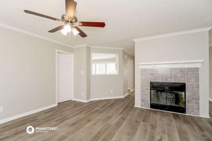the living room with fireplace and ceiling fan