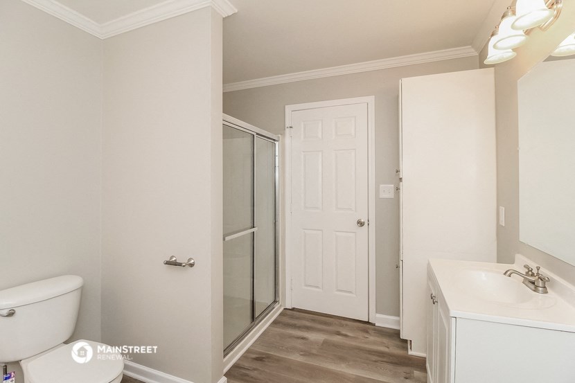 a bathroom with a toilet and a sink and a shower