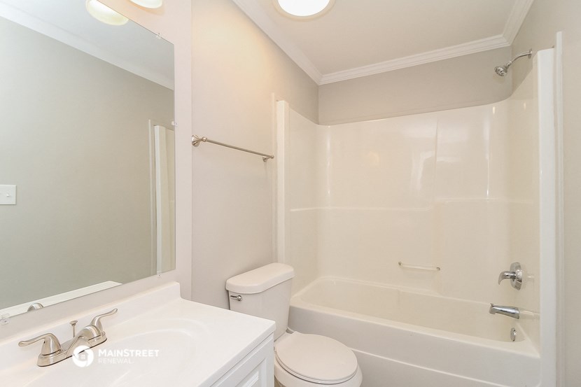 a white bathroom with a tub and a sink and a toilet