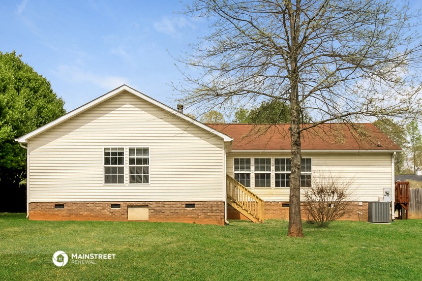 a white house with a yard and a tree