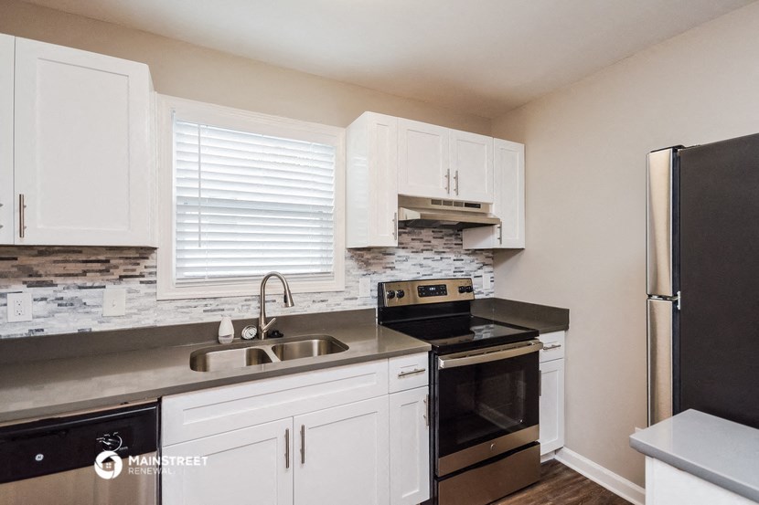 a kitchen with black appliances and white cabinets