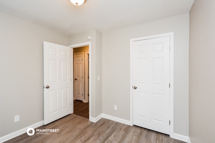 a bedroom with two doors and a door to a closet