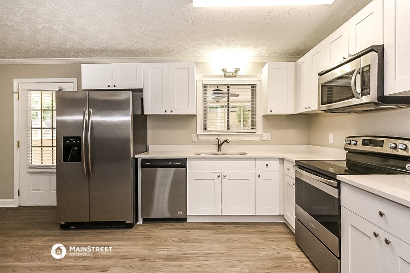 a white kitchen with stainless steel appliances and white cabinets