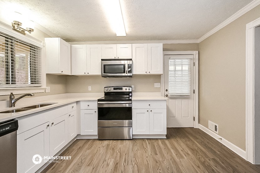 a kitchen with white cabinets and stainless steel appliances