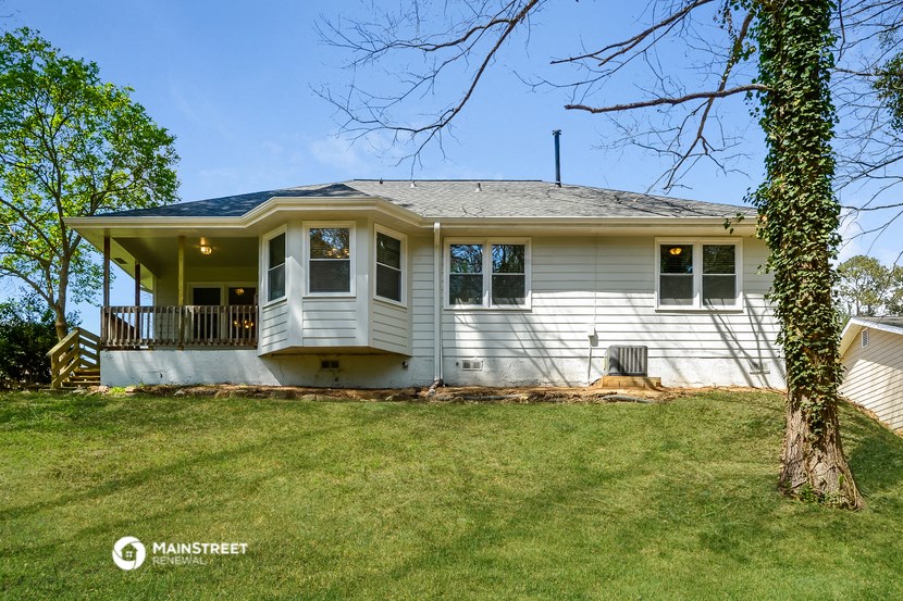 a white house with a porch and a green lawn