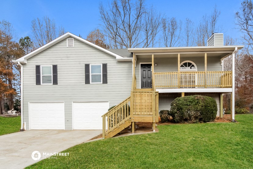 a white house with a porch and a white garage door