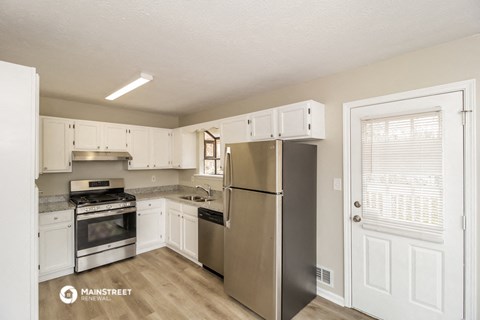 a white kitchen with stainless steel appliances and white cabinets