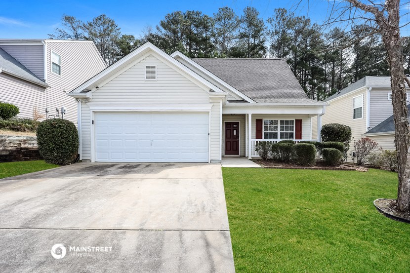 a white house with a driveway and a lawn