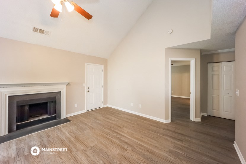 a living room with a fireplace and a door into a hallway