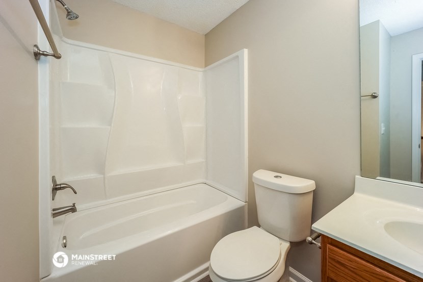 a bathroom with a toilet and a tub and a sink