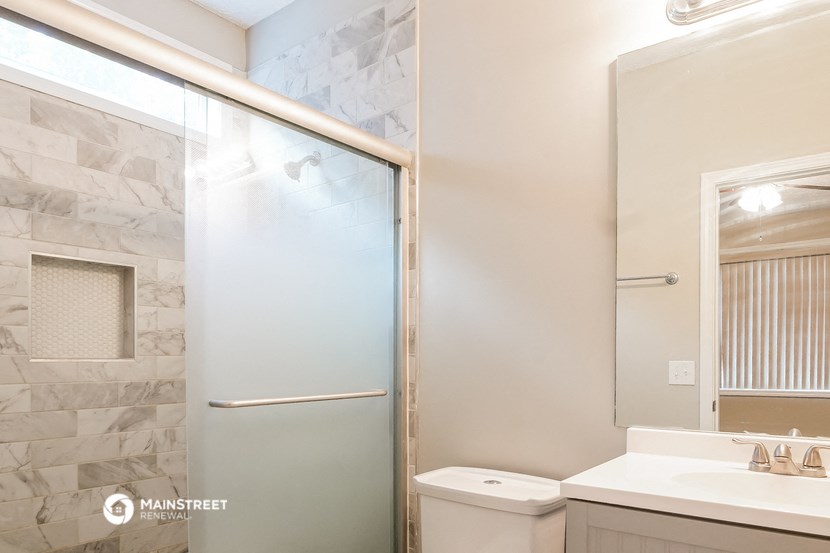 a bathroom with a shower and a sink and a toilet