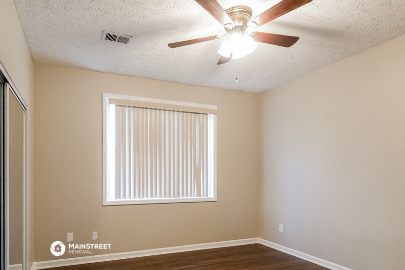 a bedroom with a ceiling fan and a window