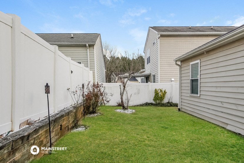 a backyard with a fence and a house