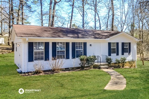 a small white house with blue shutters and a sidewalk