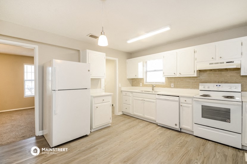 a kitchen with white appliances and white cabinets