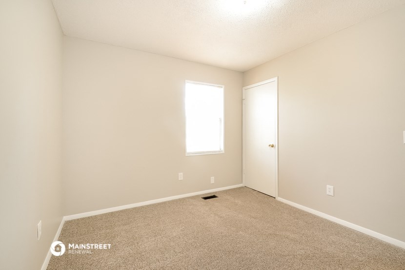 an empty room with a door and a window