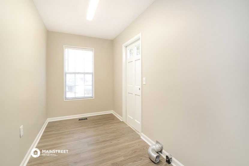 an empty room with a door and a window