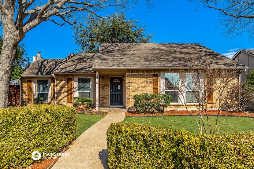 a small brick house with a sidewalk in front of it