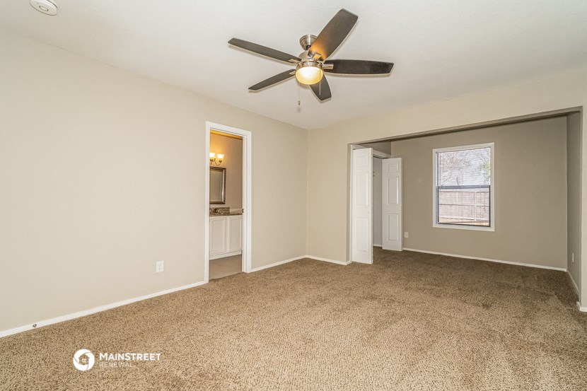 the living room of an empty house with a ceiling fan