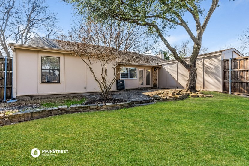 a white house with a yard and a tree