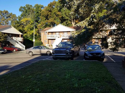 a parking lot with cars in front of a house