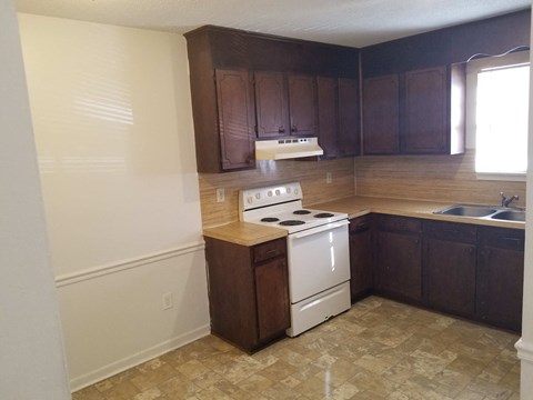 an empty kitchen with a stove and a sink