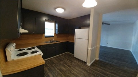 an empty kitchen with a stove and a refrigerator