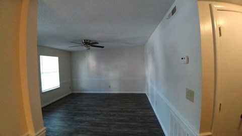 an empty room with a ceiling fan in it