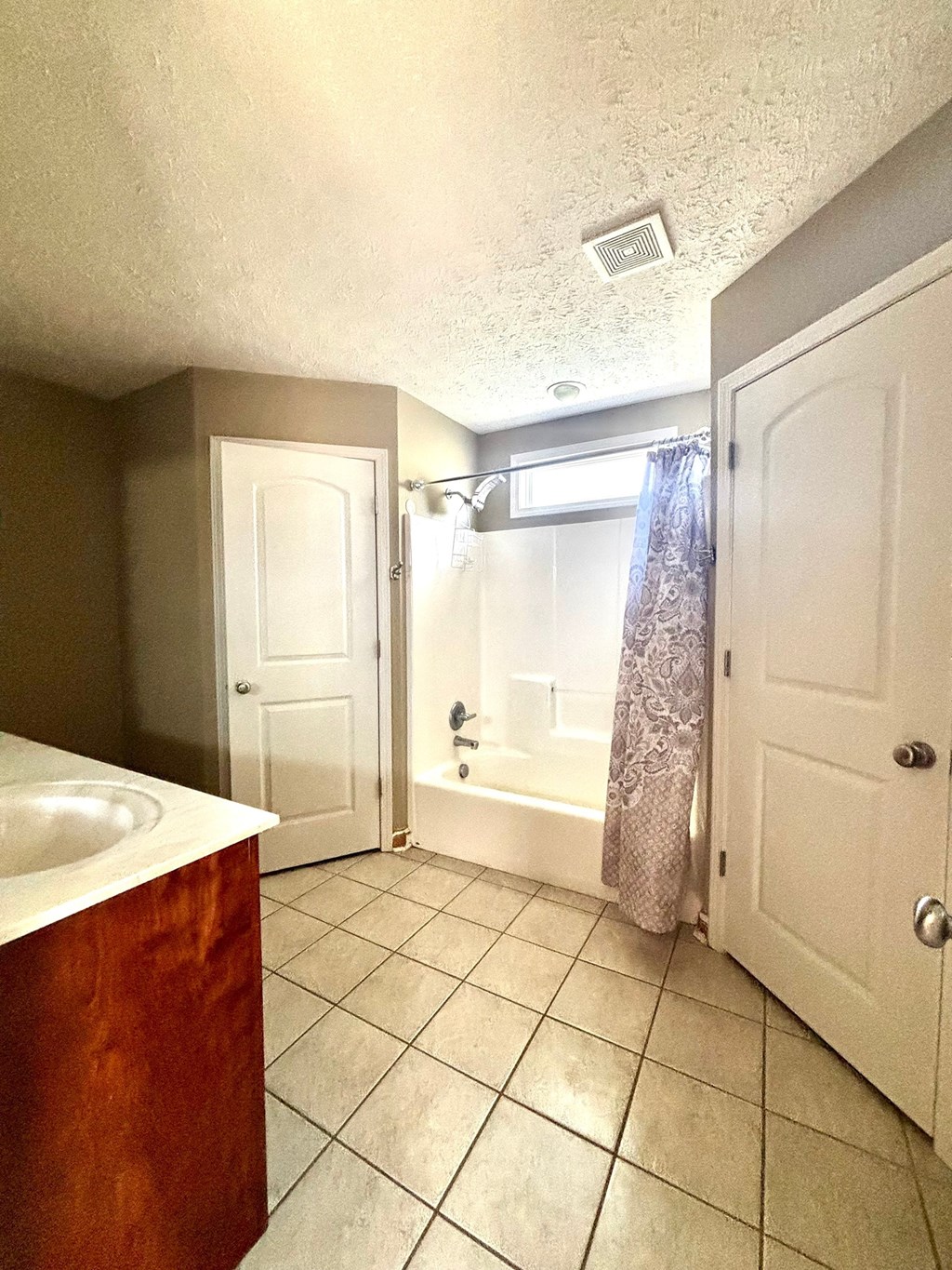 A bathroom with a white sink and a white bathtub.