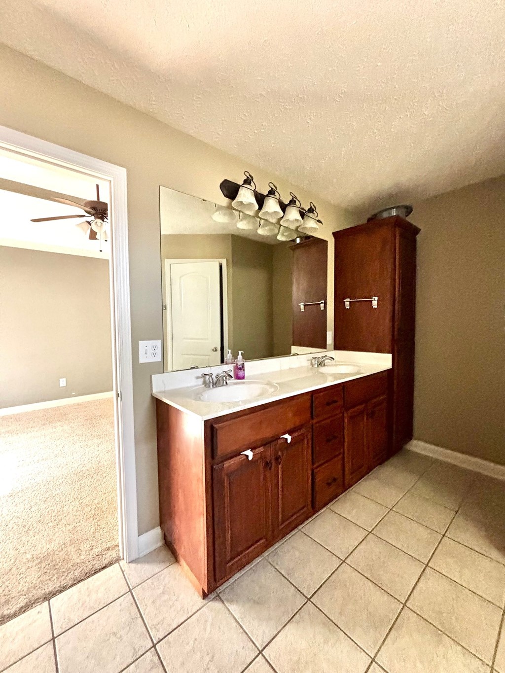 A bathroom with a sink, mirror, and cabinet.