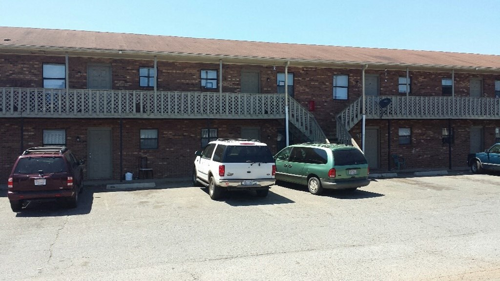 a parking lot with cars in front of a brick building